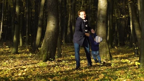 Slow motion portrait of happy young mother cuddling her baby son at autumn park Stock Footage 83091803