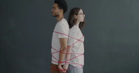 Slow motion portrait of man and woman standing back to back tied with rope on Stock Footage 237694085