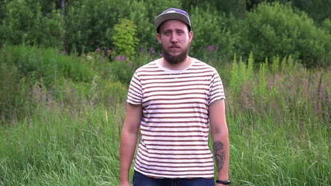 Slow motion portrait of nice bearded man with cap cross hands Stock Footage 112110606