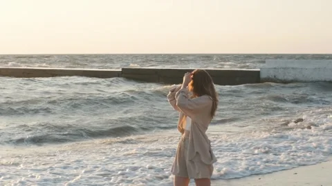 Slow motion portrait of red haired woman walking by beach at golden sunrise Stock Footage 250491887