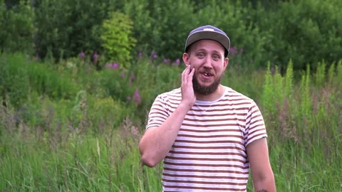 Slow motion portrait of young bearded funny man with cap OK hand gesture Stock Footage 112110098