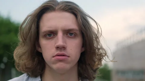 Slow motion portrait of a young long-haired man smiling Stock Footage 204804197