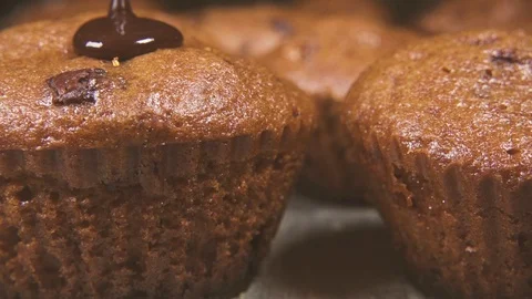 Slow motion pour the glaze over two cupcakes close up Stock Footage 96171747