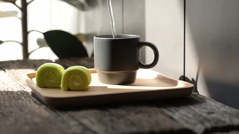 Slow motion pour of hot espresso into mug cozy coffee experience indoor setting Stock Footage 296998001