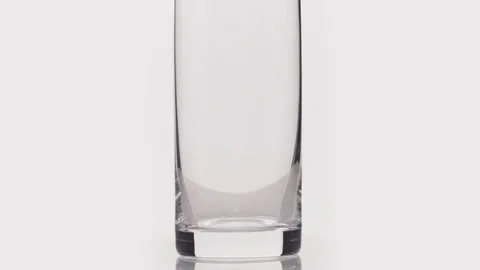 Slow motion pour lager beer into glass over white background bottom part Stock Footage