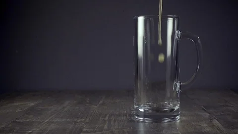 Slow motion pour light beer in a mug on a grey background Video stock 94624727