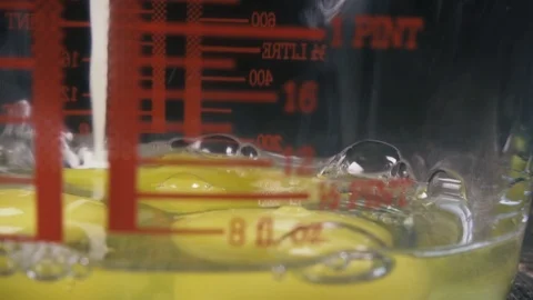 Slow motion pour milk into a measuring cup with eggs close up Video stock 96030017