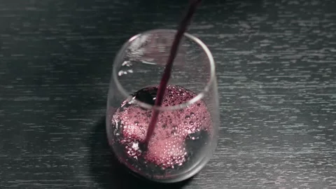 Slow Motion Pour of Red Wine into a Glass on Black Table Stock Footage 315788213