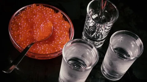 Slow motion pour the vodka in a three glass on the table with caviar top view Stock Footage 92178162