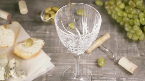 Slow motion pour the wine into a crystal glass near the cheese and grapes top Stock Footage 94079815