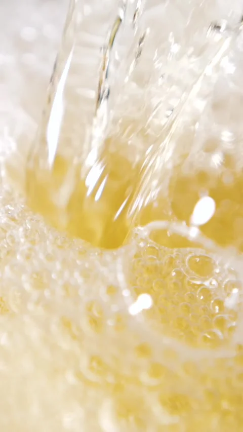 Slow motion pouring beer creates bubbles and foam in glass Stock Footage 340482633