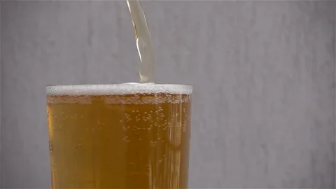 Slow motion pouring beer into a filled glass. Stock Footage 120516319