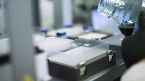 SLOW MOTION pouring a blue liquid into a scientific machine to look for a cure Stock Footage 127533436