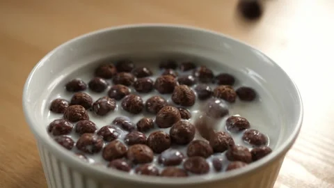 Slow motion pouring chocolate choco cereal balls into an empty white bowl Stock-Footage 294697480