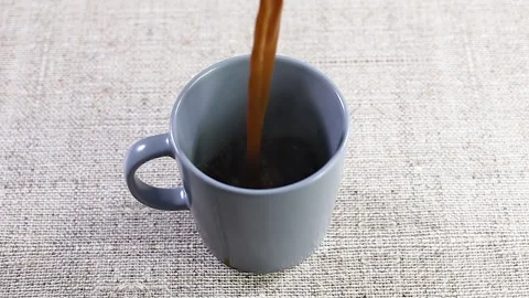 Slow motion of pouring coffee in gray cup Stock Footage 140234513