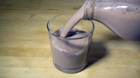 Slow motion – Pouring cold chocolate milk drink into a glass. Stock-Footage 119626850