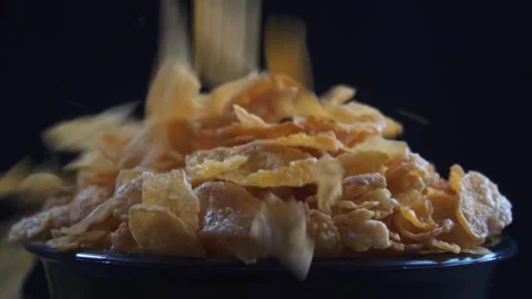 Slow motion of pouring corn flakes into bowl isolated black background 库存影片 279700449