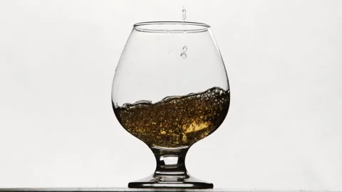 Slow motion of pouring fresh squeezzed apple juice to glass. Close up splashing Stock Footage 254549444