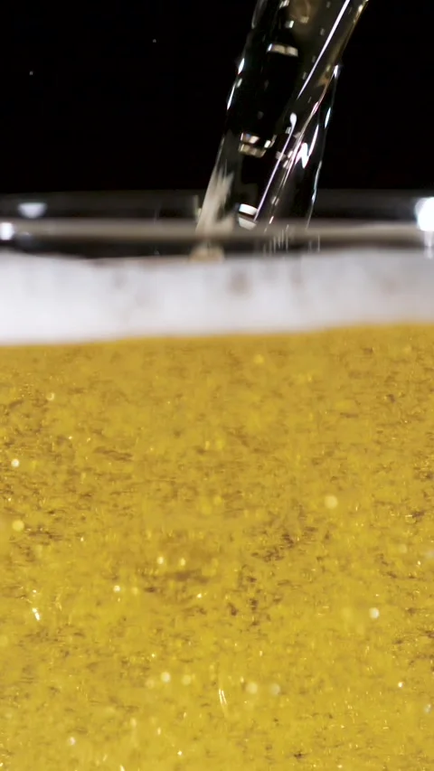 Slow Motion Pouring of Frothy Beer Revealing Bubbles and Splashes Stock Footage 340078996