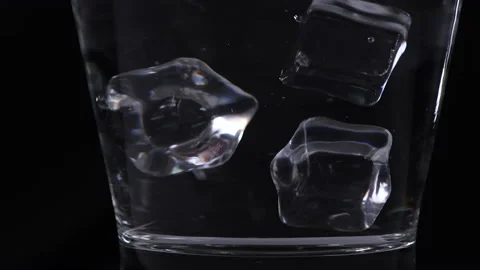 Slow motion of pouring ice cube into glass on black background, beverage Stock Footage 161174150