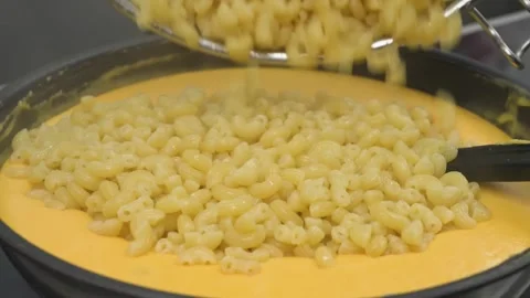 Slow Motion Pouring Macaroni Pasta into Creamy Melted Cheese Sauce Stock Footage 331633627