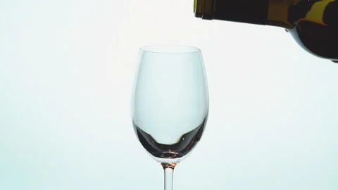 Slow motion of pouring red wine from bottle into cup on white background Stock Footage 227862211