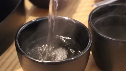 Slow Motion Pouring Tea into Black Cup Stock Footage 225665674
