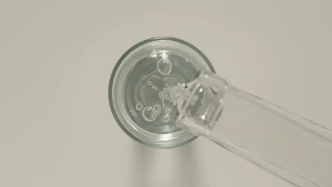 SLOW MOTION: Pouring vodka from a bottle into a glass - Top View Stock Footage 101816684