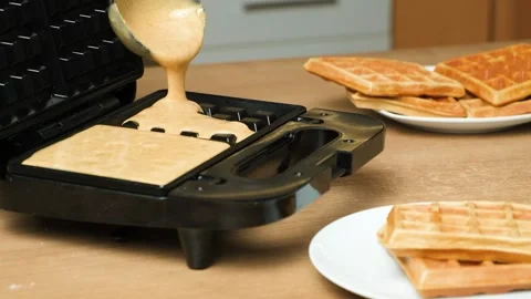 Slow motion pouring of waffle making dough into electric waffle maker. Video stock 325532209