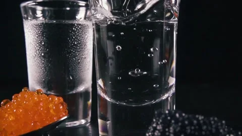 Slow-motion: Pouring water into a drinking glass on black background. splas.. Stock Footage 265847369