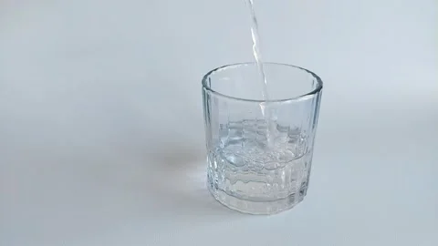 Slow Motion of Pouring Water into an Empty Glass on White Background Stock Footage 342577763