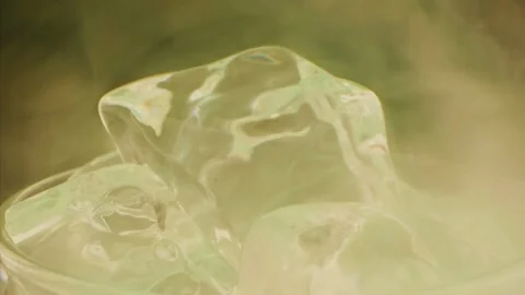 Slow motion pours beer on steam ice on green background. Slow motion 1000 fps Stock Footage 255197858