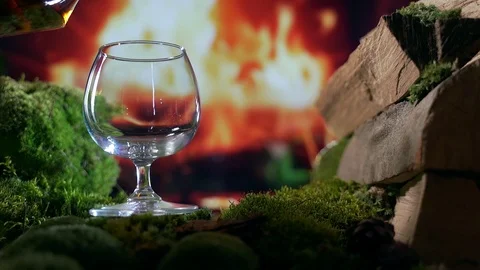 Slow motion. pours cognac or brandy into a glass. amid burning fire Stock Footage 126937421