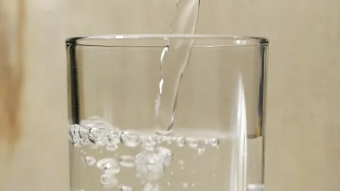 Slow motion pours spring water on spin ice cubes in turn glass.Slow motion .. Stock Footage 265843518