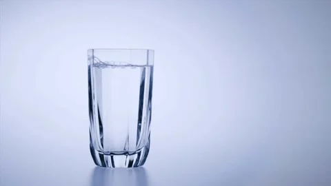 Slow motion pours spring water on spin ice cubes in turn glass.Slow motion .. Stock Footage 265847568