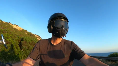 Slow motion POV selfie of biker riding at sunset with shadow on the road Stock Footage 337309310