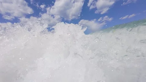 Slow motion POV shot of powerful ocean wave crashing near shore, white foam and Stock Footage 317601685