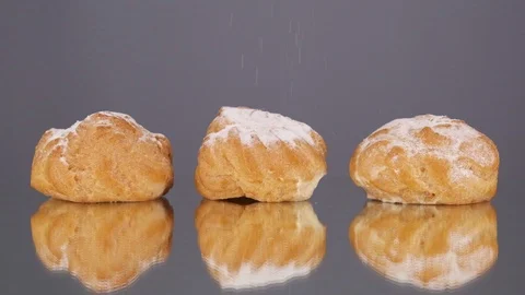 Slow motion, powdered sugar falling on eclairs cake, grey background. Stock Footage 126344716