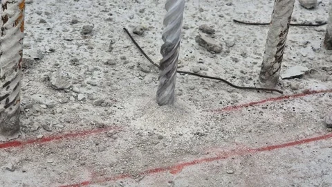Slow motion of power drill boring into concrete with falling dust Stock Footage 333249152
