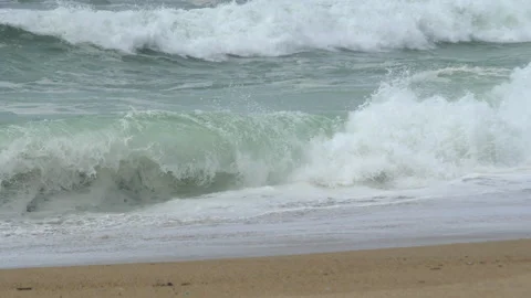 Slow motion powerful foamy white waves breaking on sandy beach. Close up. Stock Footage 271314048