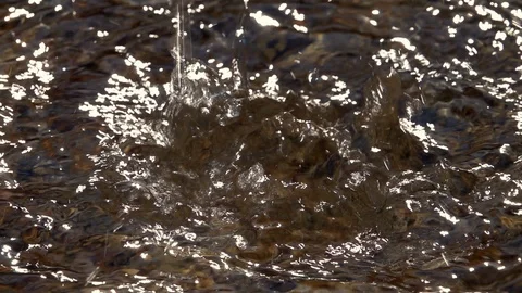 Slow motion of powerful splash in shallow pure water with pebble bottom. Stock Footage 98095627