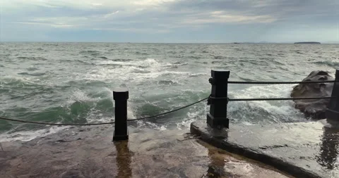 In slow motion, a powerful wave explodes against a seaside promenade Stock Footage 312565981