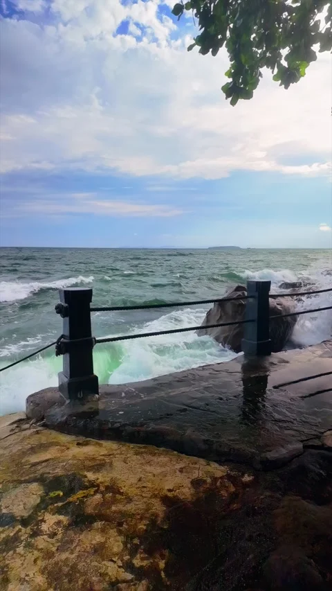 In slow motion, a powerful wave explodes against a seaside railing  Stock Footage 313093597