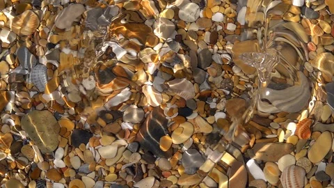Slow motion of powerful waves on shallow pure water with pebbles bottom close up Stock Footage 98098372