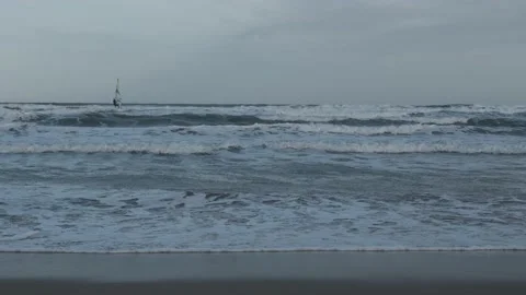 Slow motion practicing windsurfing on a beach with a lot of waves 库存影片 232952953