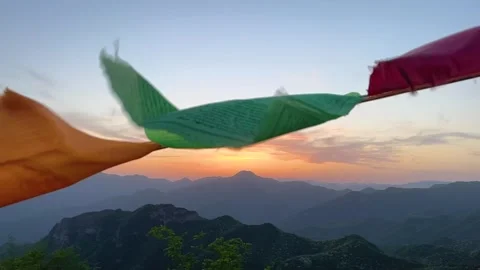 Slow motion, prayer flags flying with mountain sunset in the background 動画素材 251885263