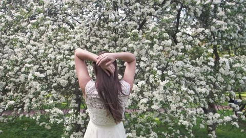 Slow motion. Pretty long brown hair lady in beautiful elegant white dress stands Stock Footage 155209810