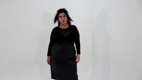 Slow motion of pretty plus size model and flying in air dress looking at camera Stock Footage 103859123