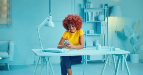 Slow motion of pretty young black woman with afro hairstyle holding smart phone Stock Footage 164381917