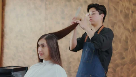 Slow motion. Pretty young client in a barber shop sitting and professional ba Stock Footage 153962120
